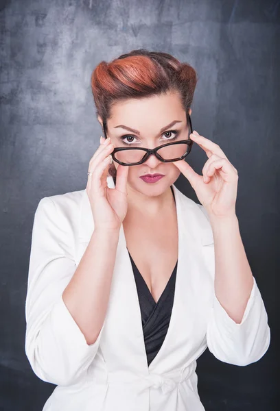 Serious teacher in glasses on blackboard background — Stock Photo, Image