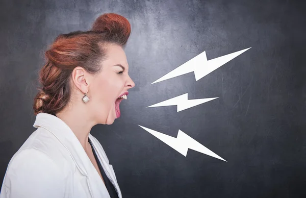 Angry screaming woman on blackboard background — Stock Photo, Image