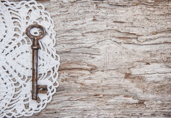 Vintage bakgrund med gammal nyckel och spets på trä — Stockfoto