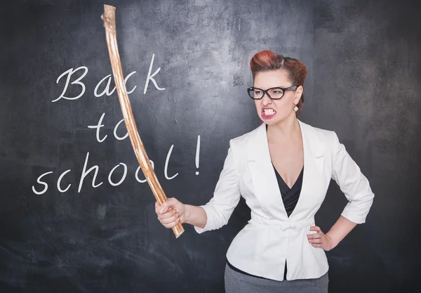 Angry screaming teacher with wooden stick on blackboard backgrou — Stock Photo, Image