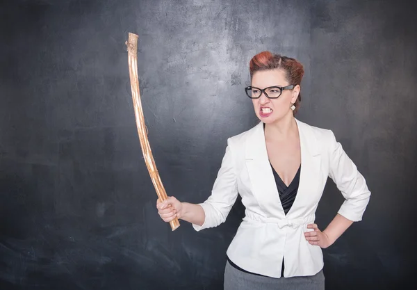 Angry screaming teacher with wooden stick on blackboard backgrou — Stock Photo, Image