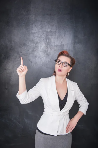 Lehrer zeigt auf etwas mit dem Finger auf Tafel Hintergrund — Stockfoto