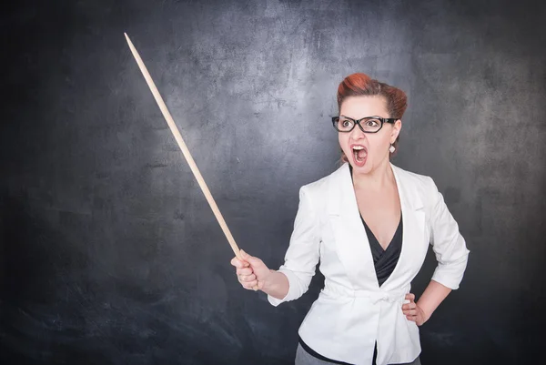 Angry screaming teacher with pointer on blackboard background — Stock Photo, Image