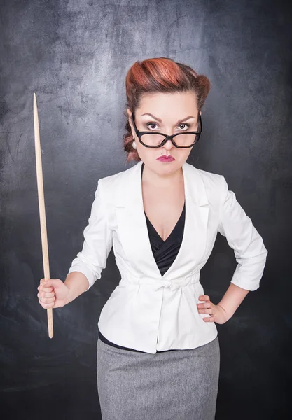 Serious teacher in glasses with pointer — Stock Photo, Image