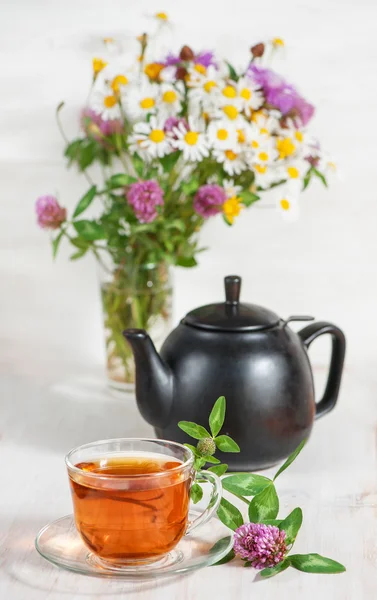 Cup of tea, teapot and branch of clover — Stock Photo, Image