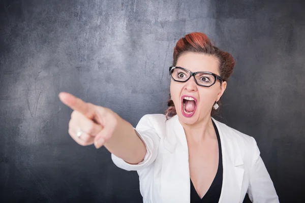 Wütend schreiende Lehrerin zeigt auf Tafel-Hintergrund — Stockfoto