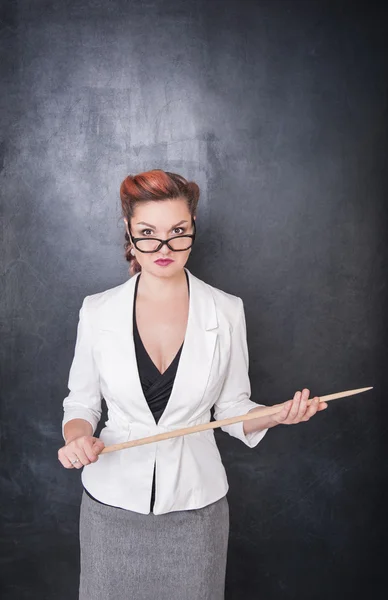 Serious teacher in glasses with pointer — Stock Photo, Image