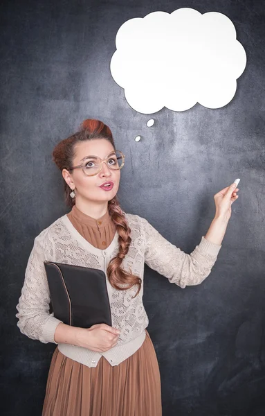 Thoughtful teacher in glasses with piece of chalk — Stock Photo, Image