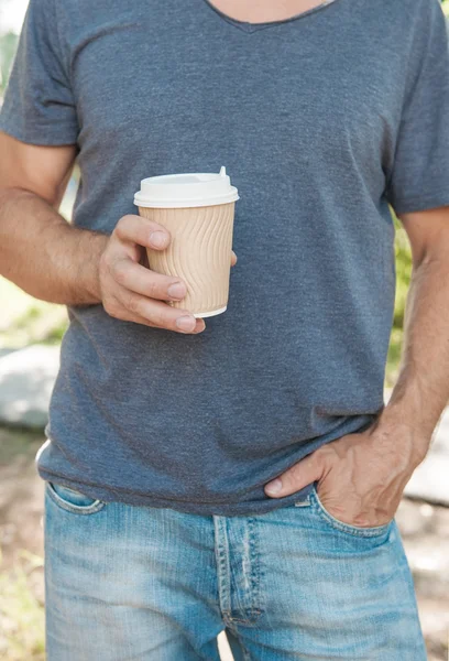Un homme tenant une tasse de café vide. Modèle de maquette — Photo