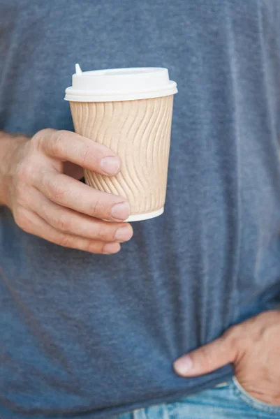 Человек держит пустую бумажную чашку кофе — стоковое фото