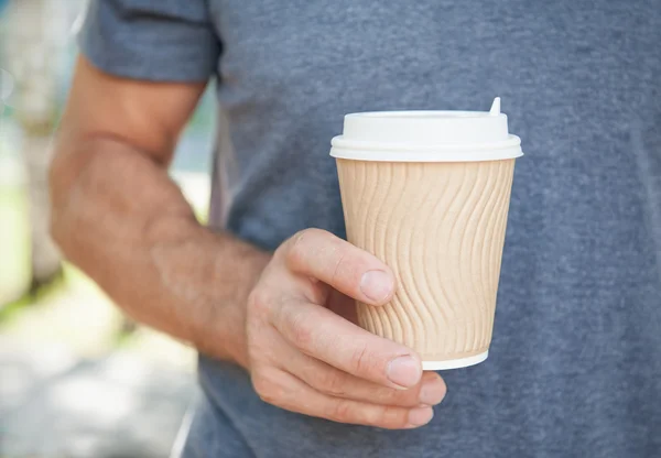 Un uomo con in mano una tazza di caffè vuota. Modello di modello up — Foto Stock