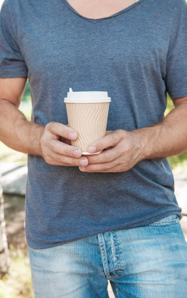 Mężczyzna, trzymając pusty dokument kawy kubek. Makieta szablonu — Zdjęcie stockowe