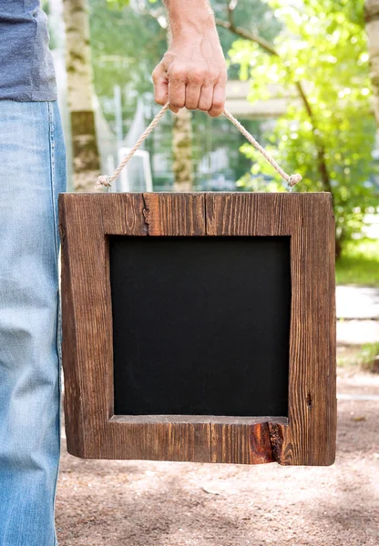 Άνθρωπος που κρατά chalkboard άδειο με ξύλινο πλαίσιο. Πρότυπο Mock up — Φωτογραφία Αρχείου