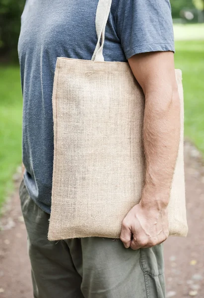 Man holding empty canvas bag. Template mock up — Stock Photo, Image