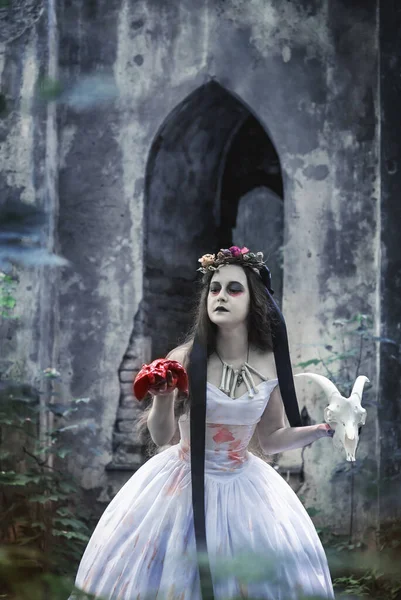 廃城の前に血の肉とヤギの頭蓋骨が立っている不気味な死んだ花嫁 ハロウィンシーン — ストック写真