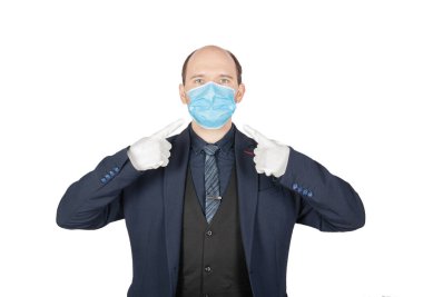 Yakışıklı genç iş adamı yüzünde cerrahi tıbbi virüs koruma maskesi ile Whit 'e izole edilmiş beyaz eldivenlerle görünüyor.