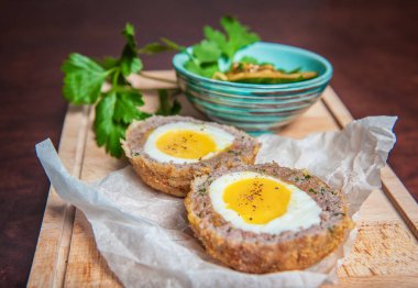 Haşlanmış yumurta, salatalık ve taze maydanozlu geleneksel İskoç et pirzolası.