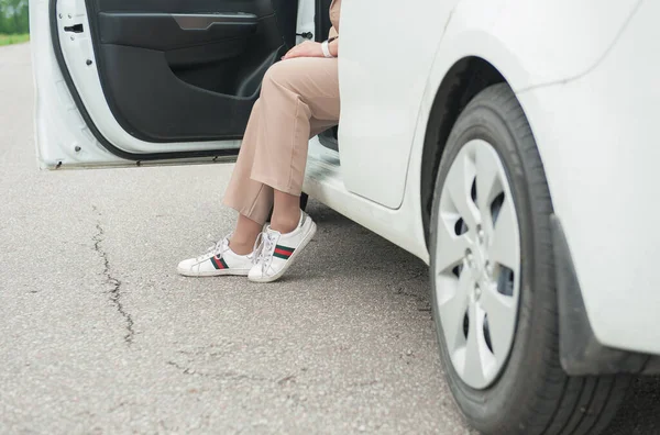 Beine Einer Frau Mit Turnschuhen Aus Weißem Auto Auf Der — Stockfoto