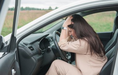 Üzgün kadın sürücü dışarıda arabada oturuyor.