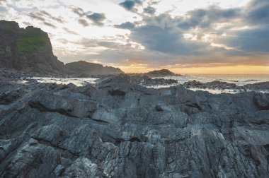 Gökyüzü zeminine karşı kaya ve deniz dalgaları.