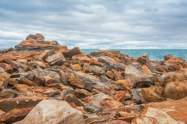 Grandes Pedras Rocha Vermelha Ondas Mar Contra Fundo Céu Dramático — Fotografia de Stock
