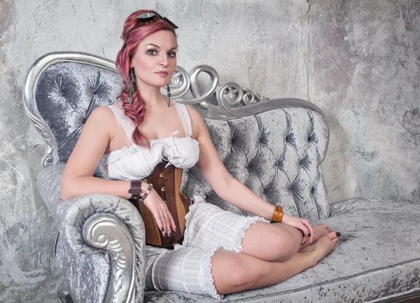 Beautiful steampunk woman on the sofa — Stock Photo, Image