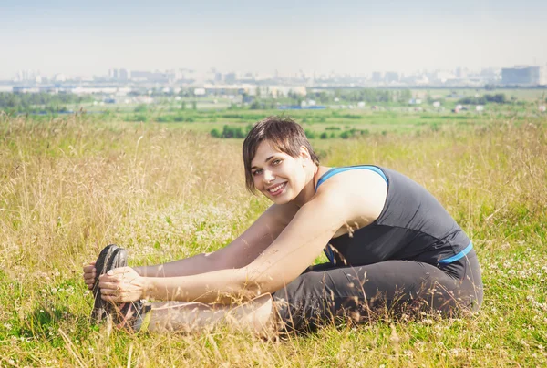 Vackra plus size kvinna stretching utomhus — Stockfoto