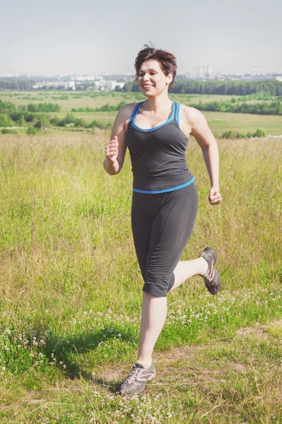 Fitness plus Größe Frau läuft im Freien — Stockfoto