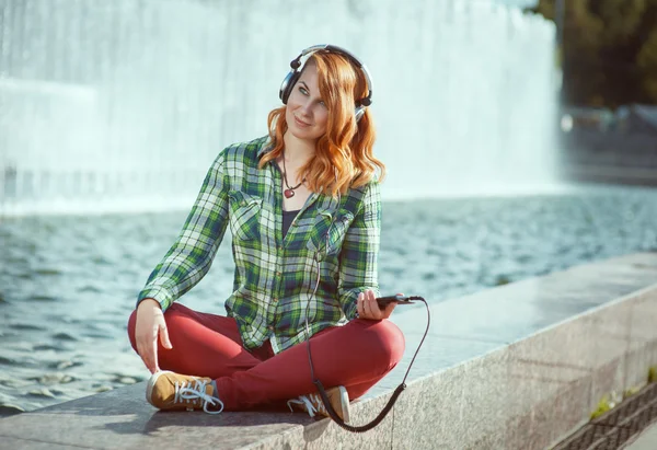 Hipster meisje met koptelefoon luisteren muziek — Stockfoto