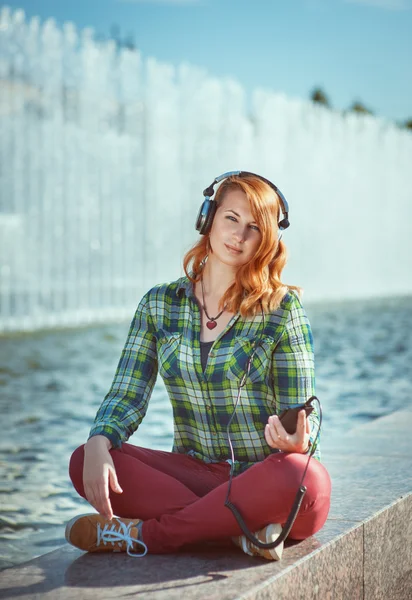 Hipster meisje met koptelefoon luisteren muziek — Stockfoto