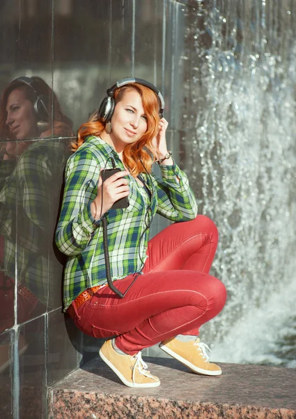 Hipster meisje met koptelefoon luisteren muziek — Stockfoto