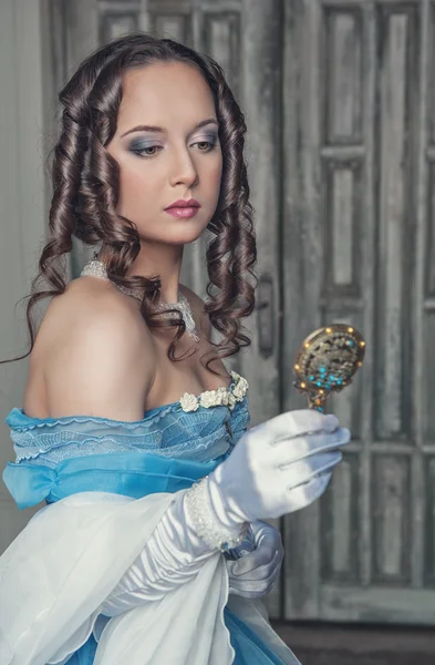 Mooie middeleeuwse vrouw in blauwe jurk met spiegel — Stockfoto