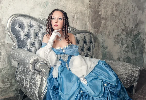 Hermosa mujer en vestido medieval en el sofá — Foto de Stock