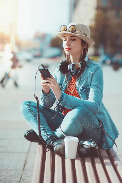 Hipster chica en sombrero y gafas escuchando música — Foto de Stock