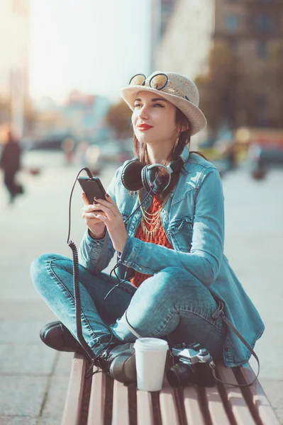 Hipster chica en sombrero y gafas escuchando música — Foto de Stock