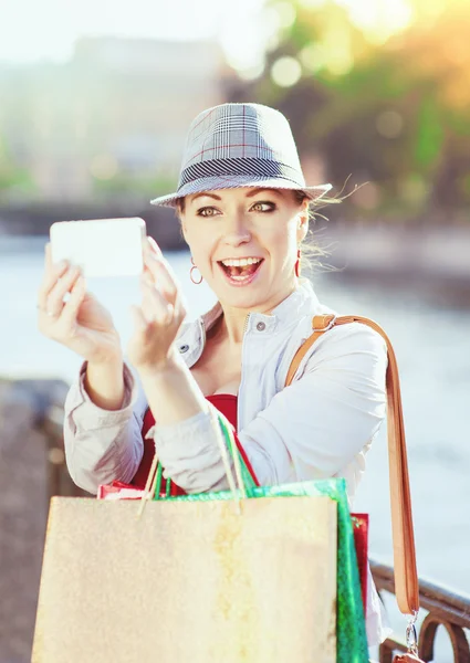 Menina bonita com sacos de compras tirou foto de si mesma — Fotografia de Stock