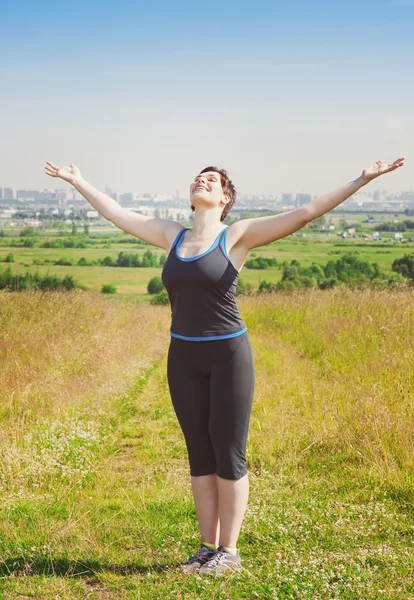 Lachende fitness plus grootte vrouw genieten van zonlicht — Stockfoto