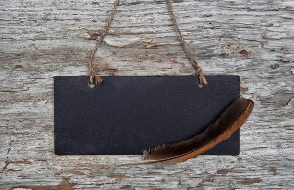 Eski ahşap üzerinde tüy ile kara tahta — Stok fotoğraf