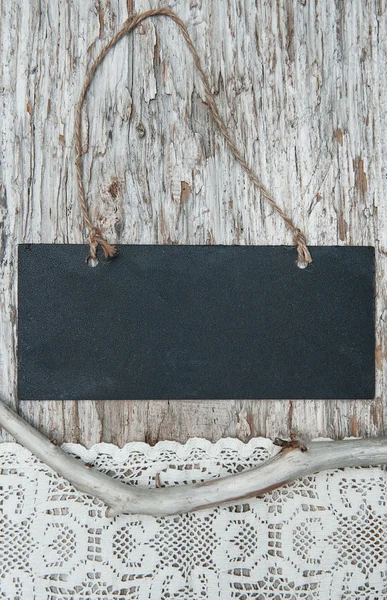 Chalkboard with lacy fabric and dry branch on old wood — Stock Photo, Image