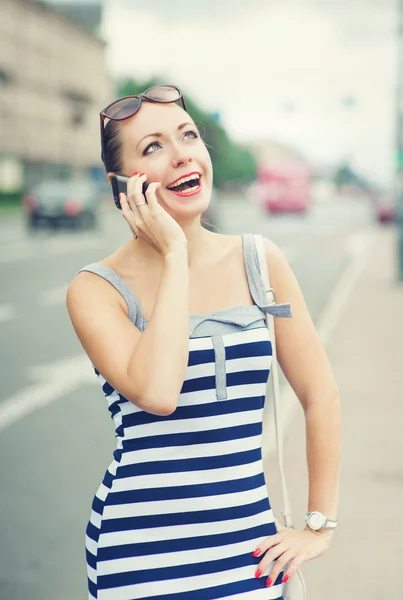 Vacker kvinna talar i mobiltelefon i staden — Stockfoto