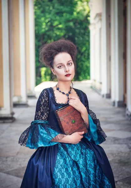 Belle femme en robe médiévale bleue avec livre — Photo