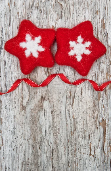 Two red woolen snowflake on the old wood background — Stock Photo, Image