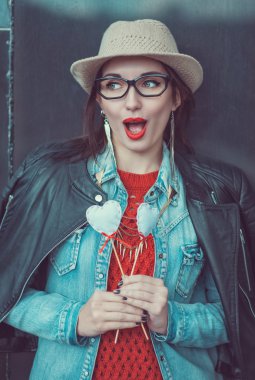 Genç güzel kız kırmızı forma ve oyuncak kalpleri ile şapka 