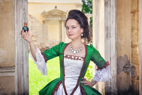 Beautiful woman in medieval dress with perfume bottle — Stock Photo, Image