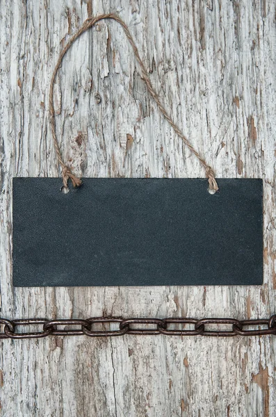 Chalkboard with metal chain on the old wood — Stock Photo, Image