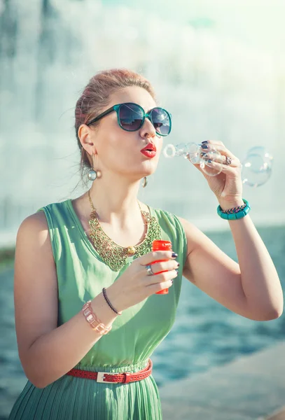 Beautiful girl in vintage clothing blowing bubbles — Stock Photo, Image