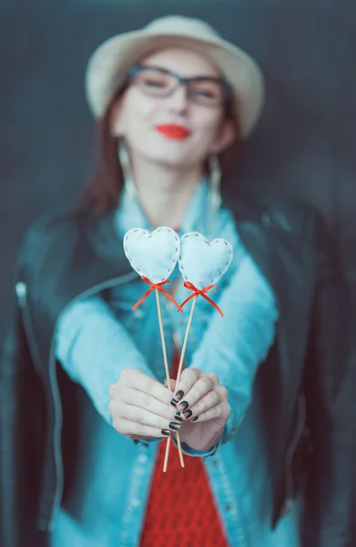 Junges schönes Mädchen mit Spielzeugherzen im Freien. Fokus auf die Herzen — Stockfoto