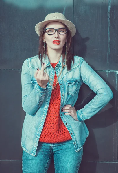 Junges schönes Mädchen in rotem Trikot und Hut mit Mittelfinger — Stockfoto