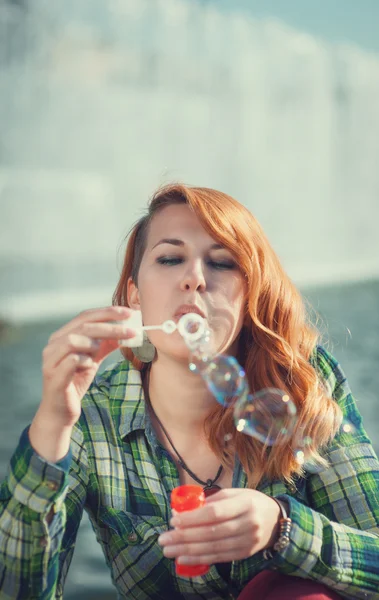 Hipster redhead girl blowing bubbles — Stock Photo, Image