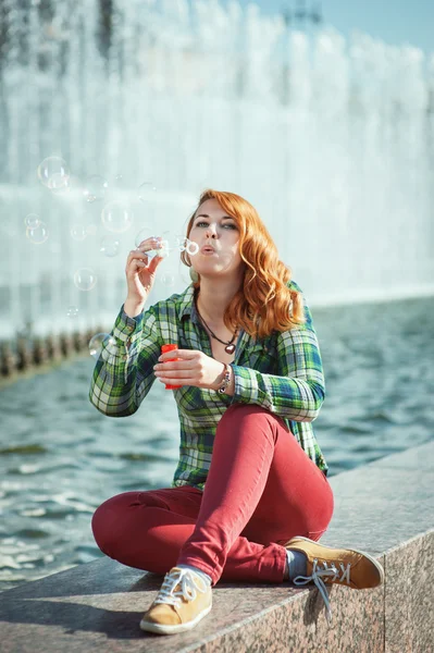 Hipster redhead girl blowing bubbles — Stock Photo, Image
